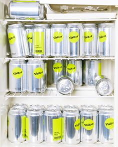 an open refrigerator filled with lots of soda cans