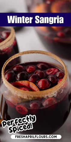 two glasses filled with sangria sitting on top of a table