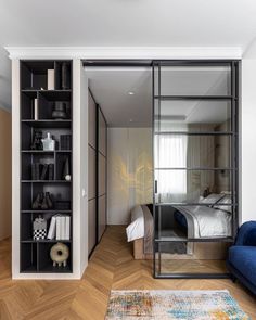 a bedroom with a blue couch and bookcase