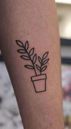 a small plant tattoo on the arm