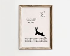 a framed art print with a deer jumping over a fence and the caption is written in black