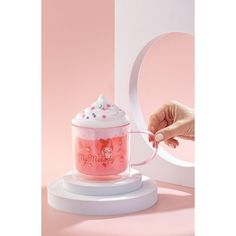 a pink frosted cup sitting on top of a white stand