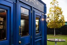 a blue phone booth sitting next to a table