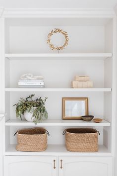 two baskets are sitting on top of a white bookcase