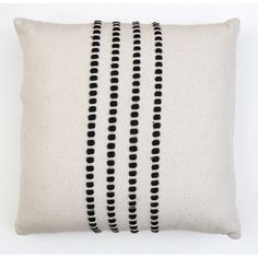 a black and white pillow with three rows of beads on the front, along with two sides