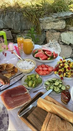 a table filled with different types of food and drinks on it's tables outdoors