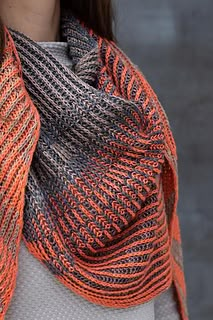 a woman wearing an orange and black knitted scarf