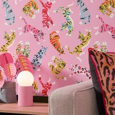 a pink wall with colorful tiger designs on it and a white lamp next to it