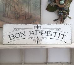 a sign that says bon appetit on it next to some pictures and plants