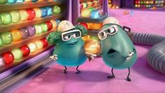 two cartoon characters wearing goggles in front of an assortment of gummy candies