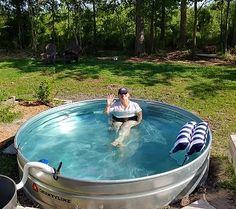 a man is sitting in the middle of a large metal barrel with water running through it