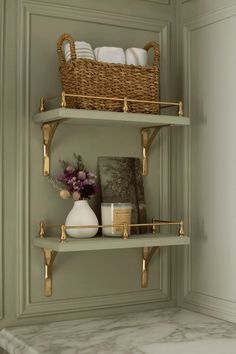 the shelves in the bathroom are decorated with gold and white decor, such as flowers