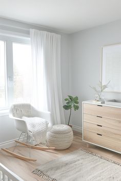 a bedroom with a rocking chair, dresser and window