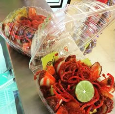 two plastic containers filled with food sitting on top of a metal counter next to each other