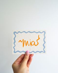 a person holding up a piece of paper with the word mias written on it