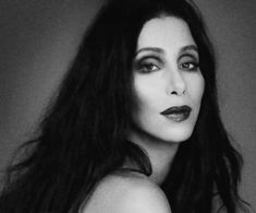 a black and white photo of a woman with long dark hair wearing lipstick on her lips