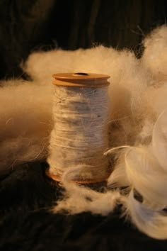 two spools of thread sitting next to each other on a black tablecloth