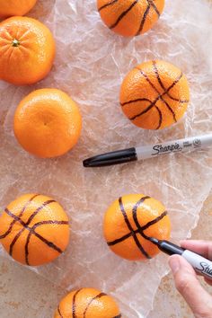 oranges with basketball painted on them are being used as markers to paint the tops