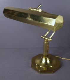 an antique brass desk lamp on a blue background