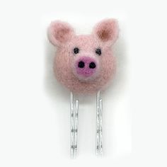 a pink felt pig head on top of two hair pins