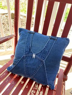 a pillow made out of an old pair of jeans is sitting on a chair outside