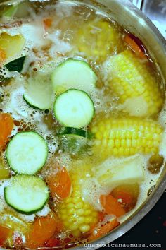 a pot filled with soup and veggies on top of a stove burner