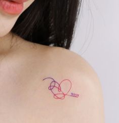 a woman with a tattoo on her shoulder has a heart and the word love written in it