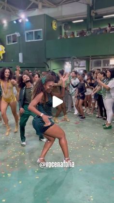 a group of young women dancing in a gym with confetti all over the floor