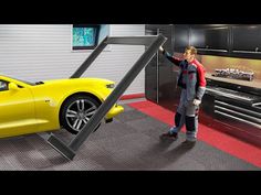 a man standing next to a yellow sports car in a garage with the door open