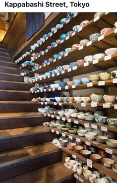 there are many bowls on the shelves in this room