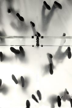 black and white photograph of an array of cell phones in front of a glass wall