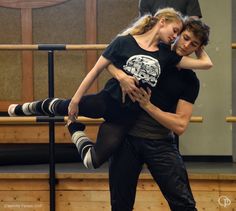 a man and woman dance together in front of a stage with other dancers behind them