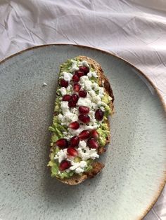 an avocado toast with pomegranate and feta cheese on it