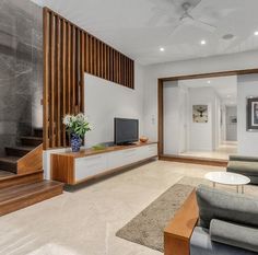 a living room with couches, chairs and a flat screen tv on the wall