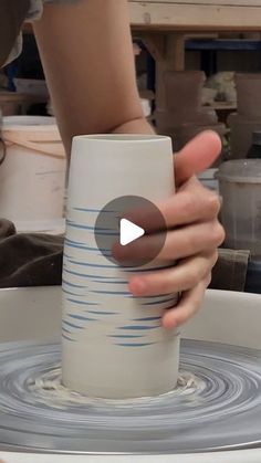 a person holding a cup in the middle of a bowl