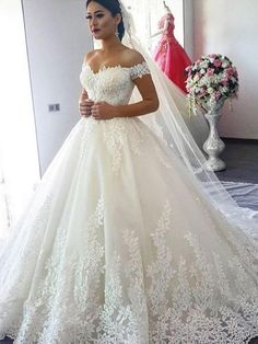 a woman in a wedding dress standing next to a mirror