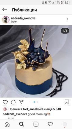 the cake is decorated with blueberries and gold leaves