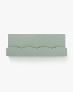 a green shelf with wavy lines on the top and bottom, against a white background