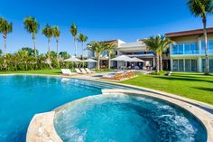 an outdoor swimming pool surrounded by palm trees