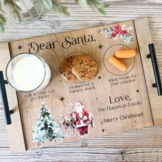 a wooden cutting board with cookies, milk and crackers on it that says dear santa