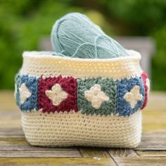 a crocheted basket sitting on top of a wooden table