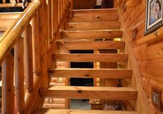 a wooden stair case with pictures on the wall