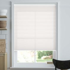 a kitchen window with white blinds in it