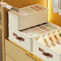 an open drawer with two bins filled with clothes