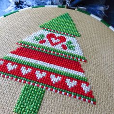 a cross - stitch christmas tree ornament is displayed