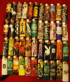 many different types of lighters lined up on a red carpeted floor in rows