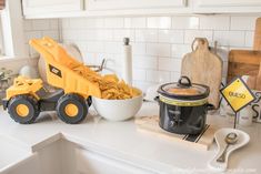 a crock pot filled with macaroni and cheese sitting on top of a counter