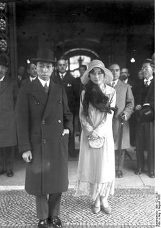 an old black and white photo of a woman standing in front of a group of men