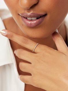 a close up of a person wearing a white shirt and a ring on her finger