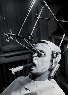 a man in a white shirt has his face painted like a person with multiple instruments on top of his head